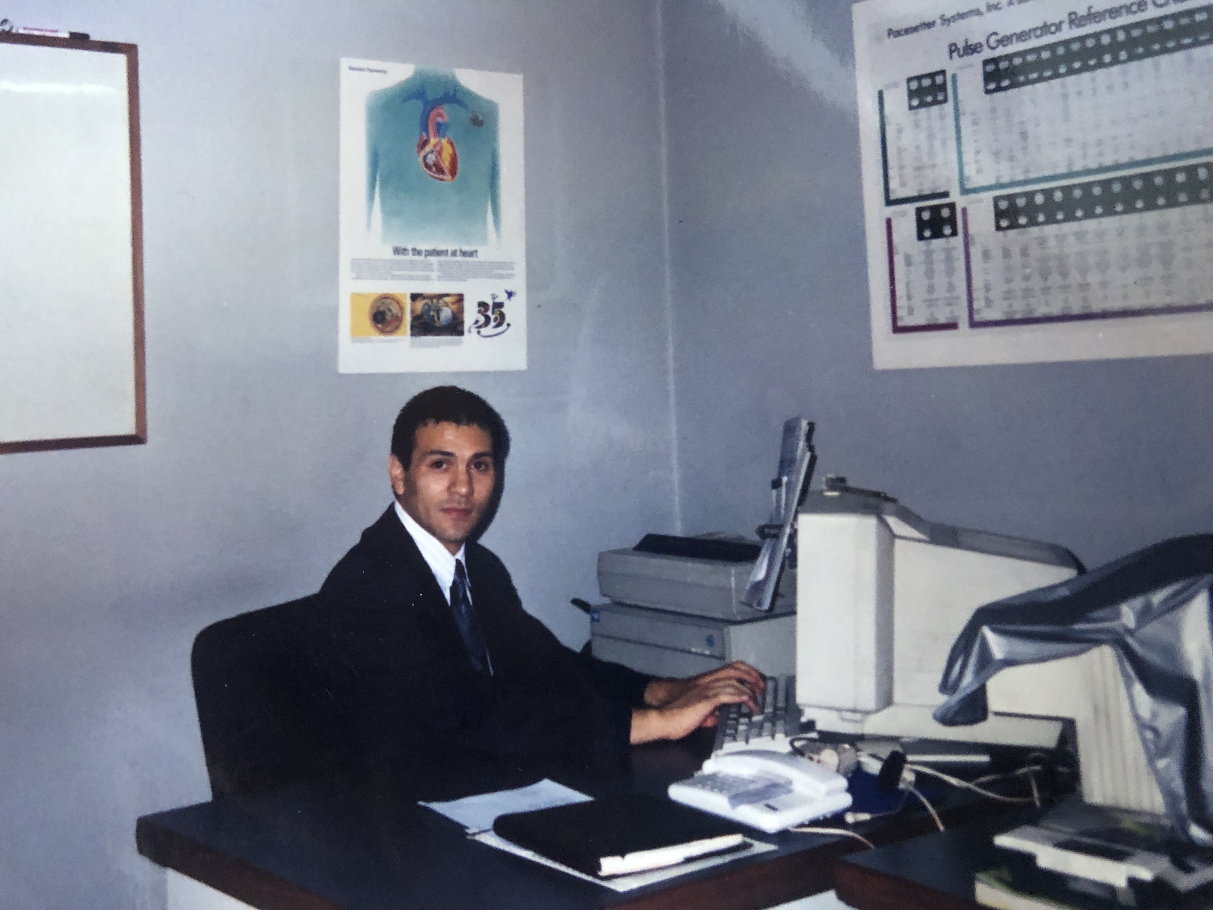 Old picture of Juan Villegas working in a office.